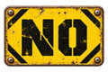 NO in black stencil type on a distressed yellow industrial sign.